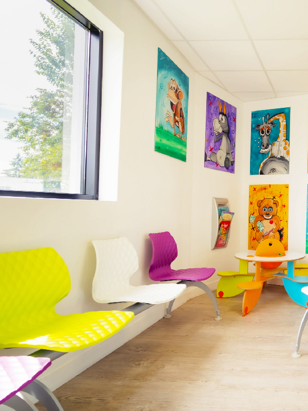 Banquette sur poutre de la collection DIAMS dans une salle d’attente de cabinet dentaire, coques colorées pop art avec dessins d’enfants et animaux