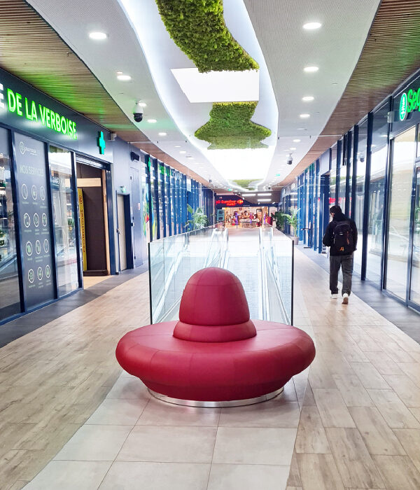 Banquette circulaire SUMO sur mesure en simili cuir rouge M1 installée dans galerie commerciale face aux boutiques