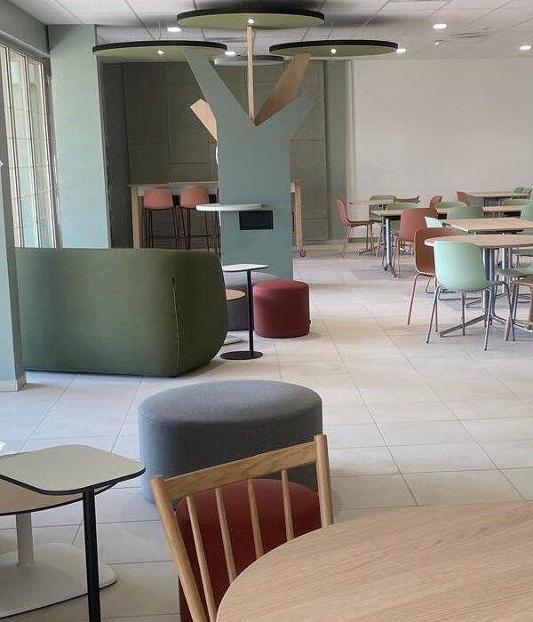 Cafétéria ESSCA aménagée avec canapés CONFIDENT et poufs verts pour espace détente en campus d’enseignement supérieur