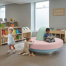 Aménagement d'un espace enfants d'une bibliotheque avec une banquette circulaire ronde